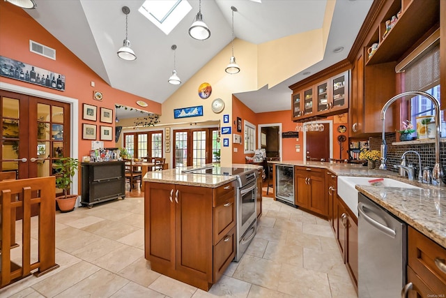 kitchen featuring beverage cooler, stainless steel appliances, visible vents, french doors, and brown cabinets