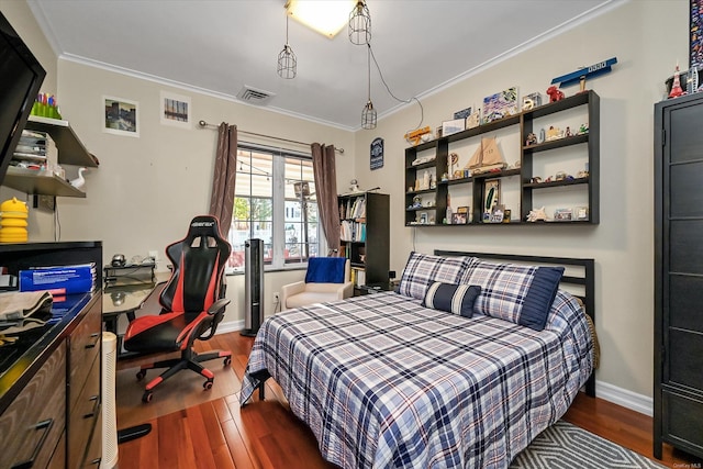 bedroom featuring baseboards, visible vents, wood finished floors, and ornamental molding