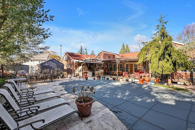 back of property with outdoor dining space and a patio area