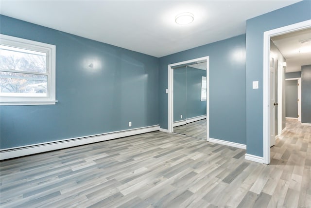 empty room featuring light hardwood / wood-style floors and a baseboard heating unit