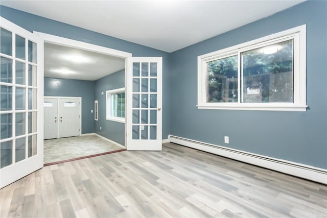 entryway with light wood-type flooring, a baseboard radiator, and french doors