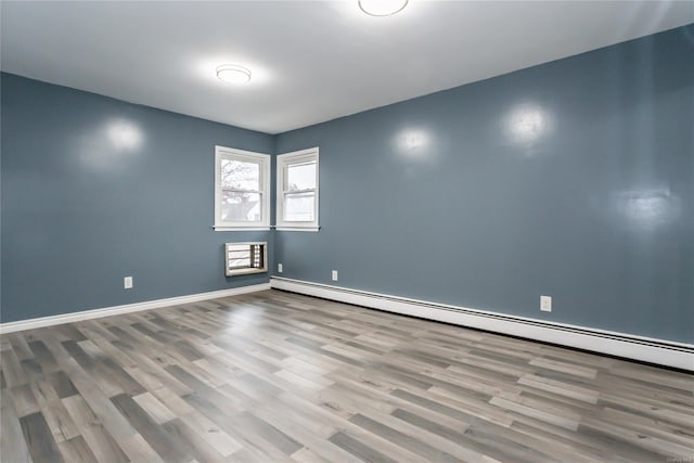 unfurnished room featuring light hardwood / wood-style floors and baseboard heating