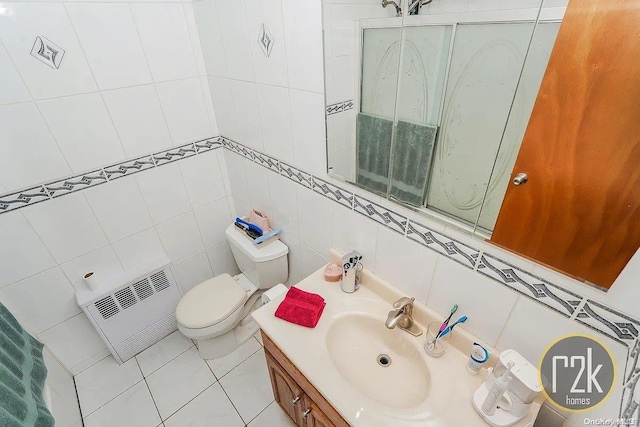 bathroom featuring tile patterned floors, vanity, radiator heating unit, and tile walls