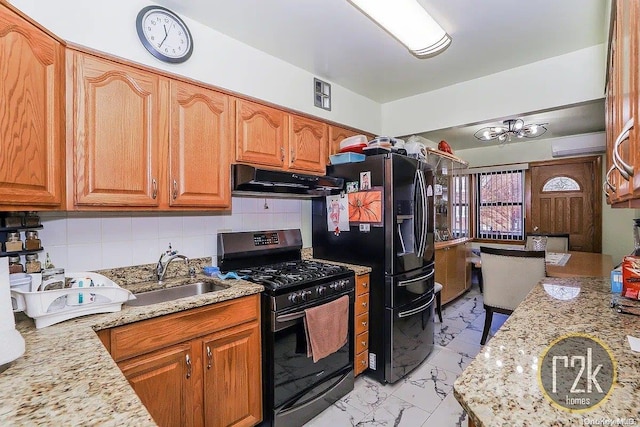 kitchen with light stone countertops, decorative backsplash, sink, and black appliances