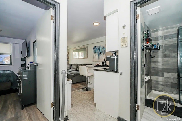 bathroom featuring hardwood / wood-style floors, plenty of natural light, and lofted ceiling