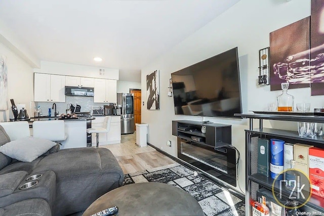 living room featuring sink and light hardwood / wood-style flooring