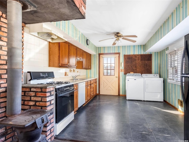 kitchen featuring ceiling fan, sink, washer and dryer, and white appliances