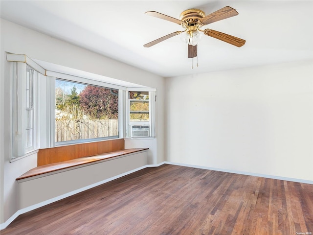 empty room featuring dark hardwood / wood-style flooring, ceiling fan, and cooling unit