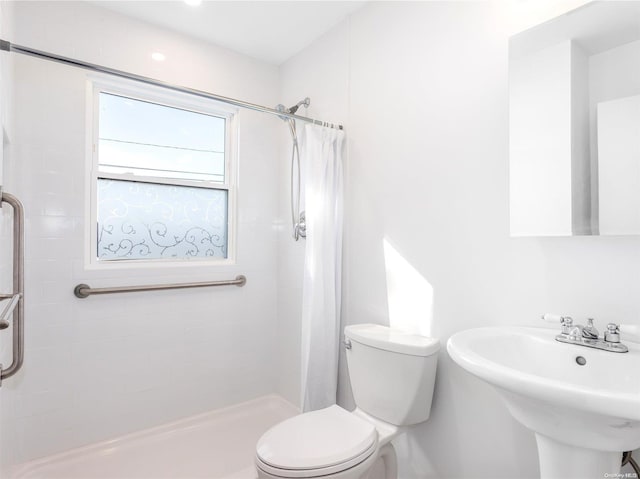 bathroom featuring a shower with curtain, sink, and toilet