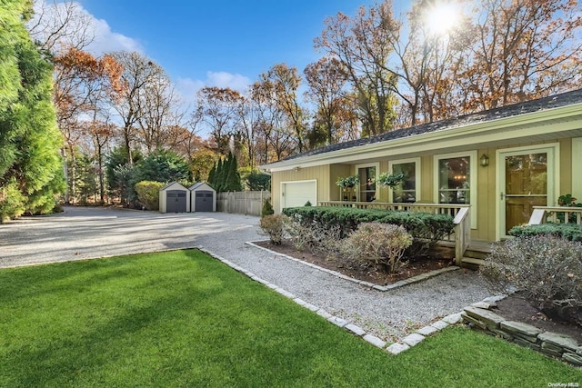 view of yard featuring a storage unit, a garage, and covered porch