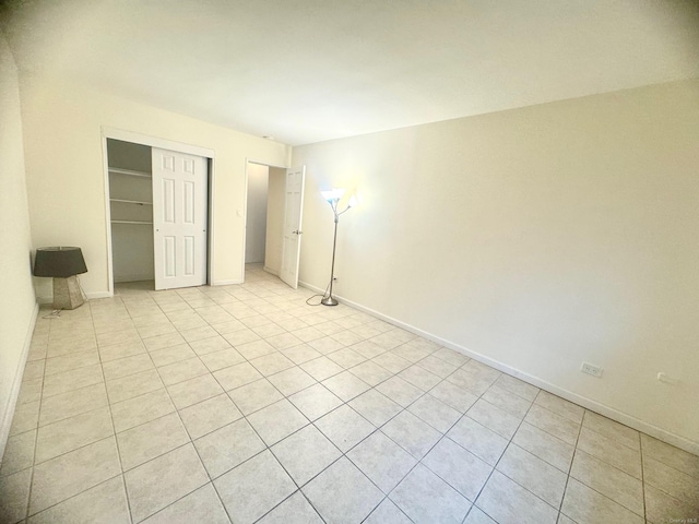 unfurnished bedroom featuring light tile patterned flooring and a closet