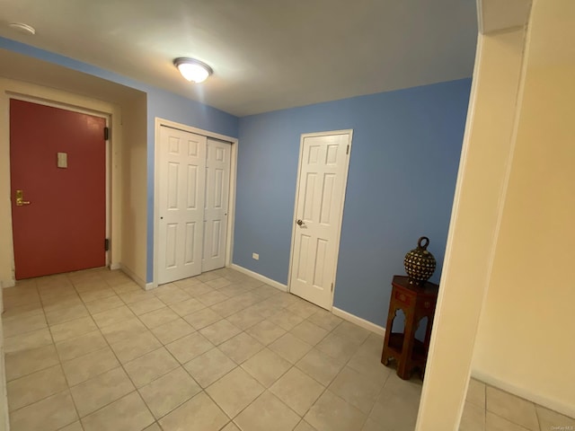 unfurnished bedroom with light tile patterned flooring and a closet