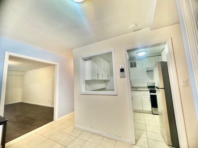 hallway featuring sink and light tile patterned flooring