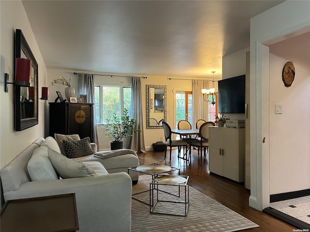 living room with dark hardwood / wood-style floors and an inviting chandelier