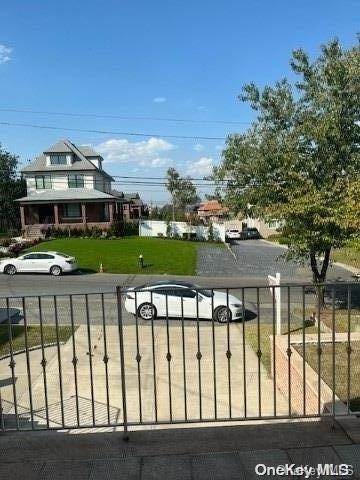 view of gate with a lawn