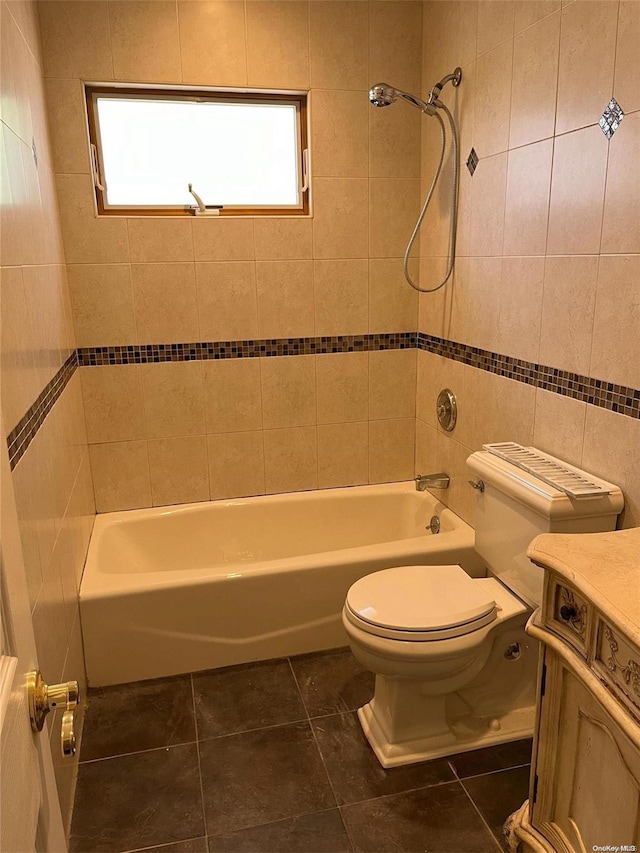 full bathroom with tile patterned floors, vanity, tile walls, toilet, and tiled shower / bath