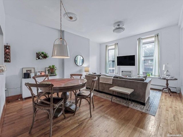 dining space featuring baseboard heating and wood-type flooring