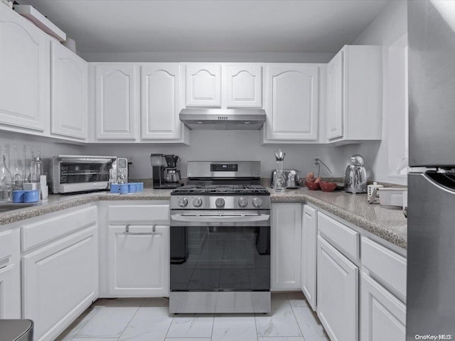 kitchen featuring appliances with stainless steel finishes, white cabinetry, and range hood