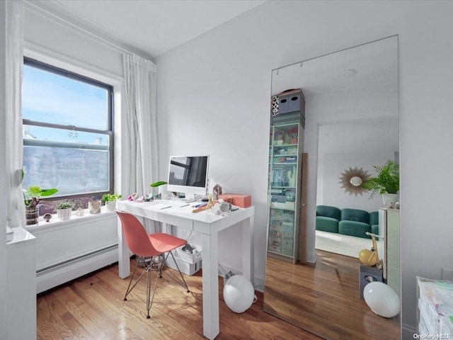 office area featuring baseboard heating and hardwood / wood-style flooring