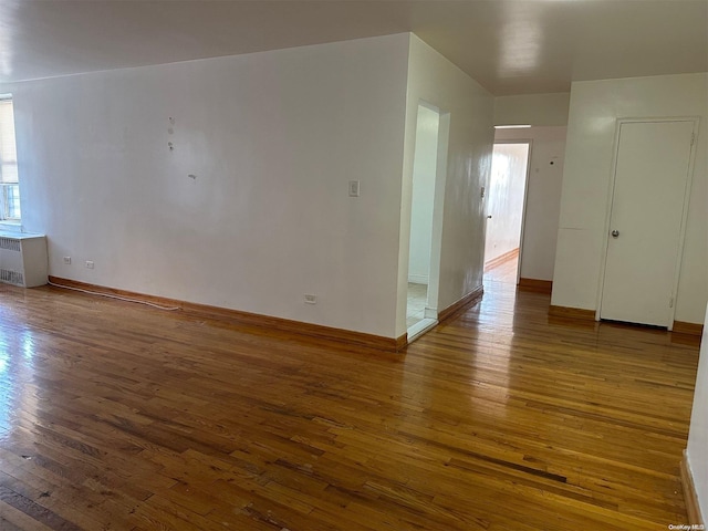 spare room with radiator and wood-type flooring