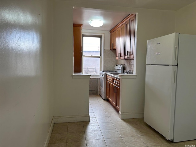 kitchen featuring light tile patterned floors, backsplash, and white appliances