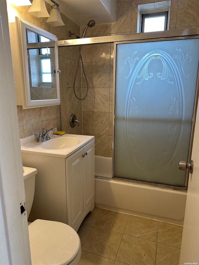 full bathroom featuring enclosed tub / shower combo, tile patterned floors, vanity, and toilet