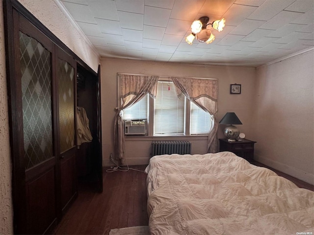 bedroom featuring radiator, cooling unit, and dark wood-type flooring