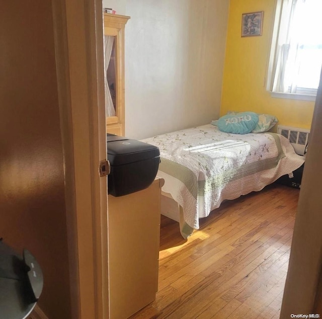 bedroom featuring radiator heating unit and light hardwood / wood-style floors