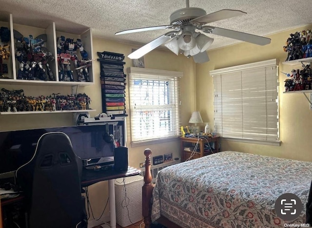 bedroom with ceiling fan and a textured ceiling