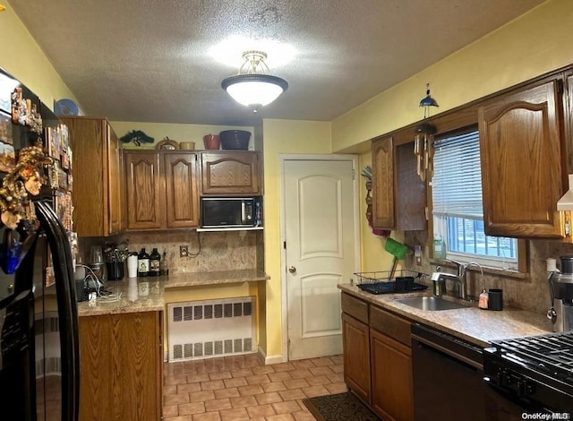 kitchen with radiator, decorative backsplash, sink, and black appliances