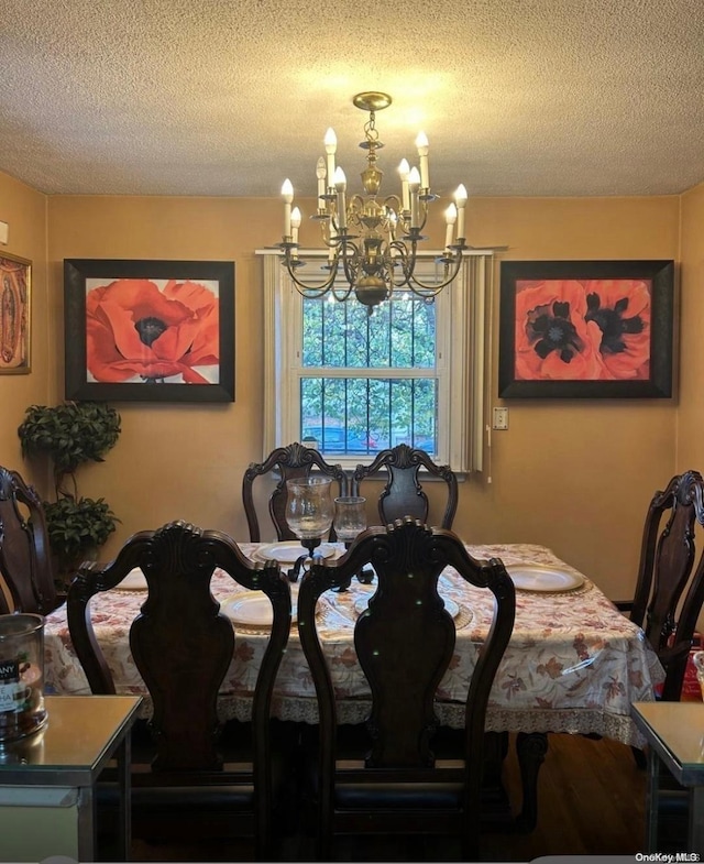 dining room featuring wood-type flooring, a textured ceiling, and an inviting chandelier