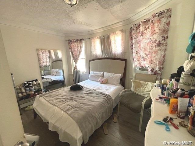 bedroom with hardwood / wood-style floors and a textured ceiling