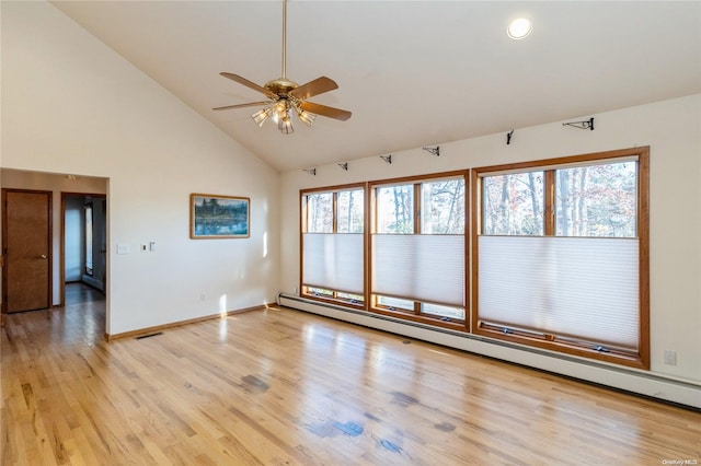 unfurnished room with plenty of natural light, ceiling fan, light wood-type flooring, and baseboard heating