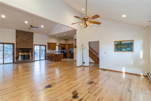 1572 Middle Rd, Calverton, NY 11933 - unfurnished living room featuring a ceiling fan, high vaulted ceiling, light wood-type flooring, stairway, and baseboards