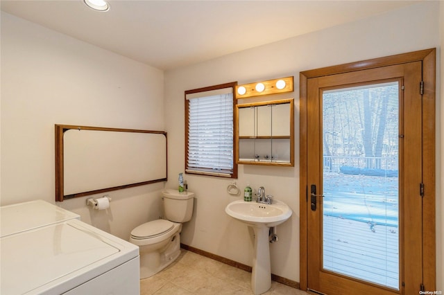 bathroom with sink, tile patterned flooring, washer and dryer, and toilet