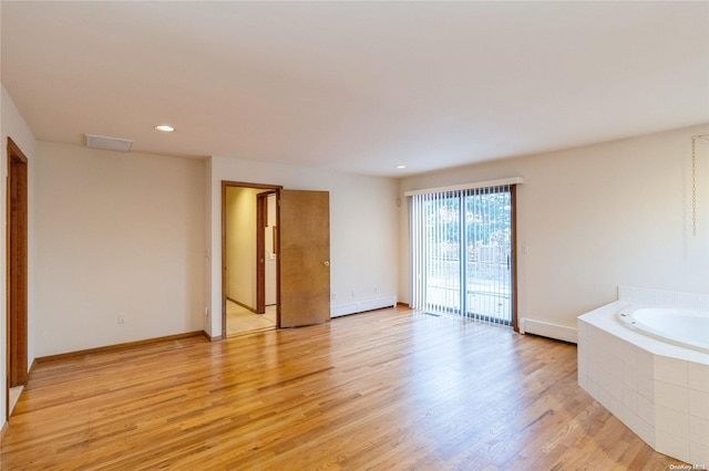 empty room with light hardwood / wood-style flooring and a baseboard radiator