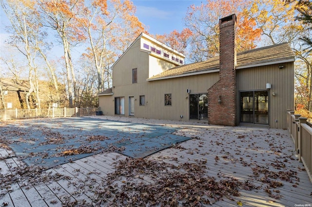 rear view of house featuring a covered pool