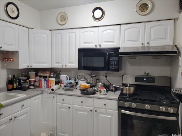 kitchen with decorative backsplash, sink, white cabinets, and stainless steel gas range