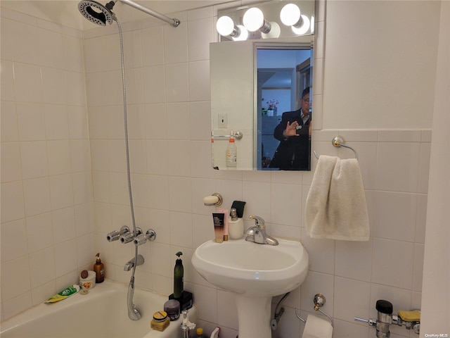 bathroom featuring sink, tile walls, and tiled shower / bath