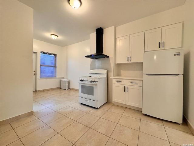 kitchen featuring white appliances, wall chimney range hood, decorative backsplash, light tile patterned flooring, and white cabinetry