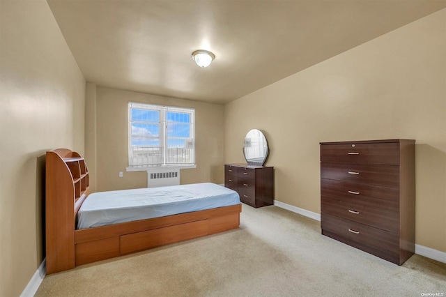 bedroom with radiator and light colored carpet