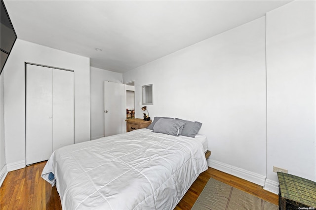 bedroom with dark wood-type flooring and a closet