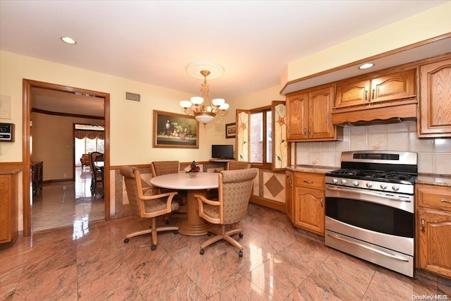 kitchen with gas range, a wealth of natural light, a chandelier, and decorative light fixtures