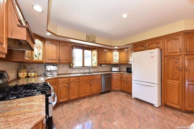 kitchen featuring decorative backsplash, sink, light stone countertops, and stainless steel appliances