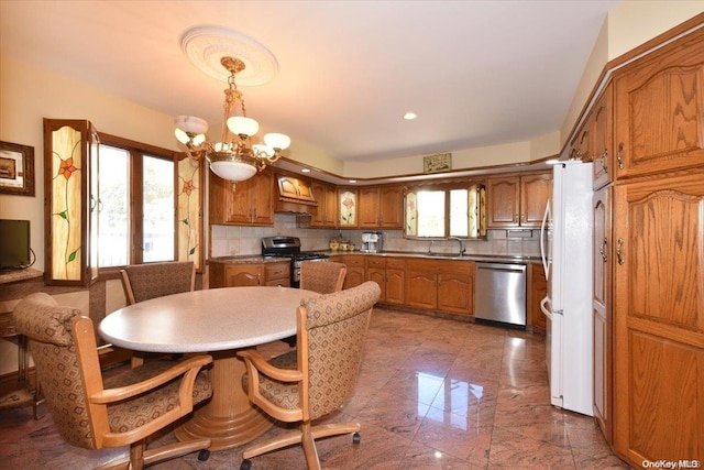 kitchen with decorative light fixtures, backsplash, appliances with stainless steel finishes, and a chandelier