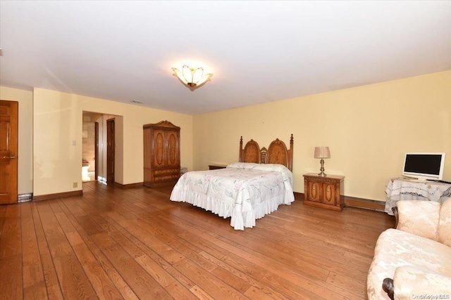 bedroom with hardwood / wood-style flooring and a baseboard radiator