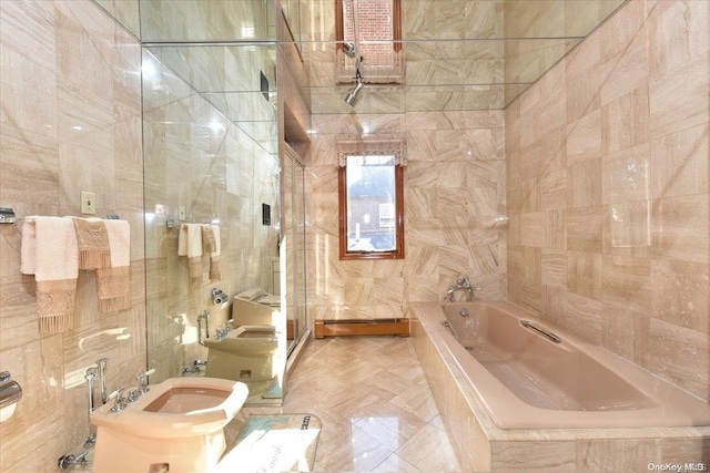 bathroom with a bidet, tile walls, and toilet