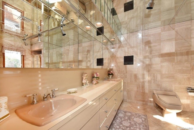 bathroom featuring vanity, toilet, and tile walls