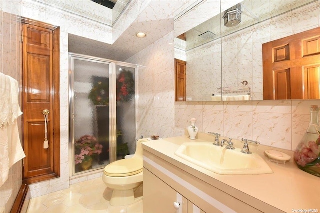 bathroom with a skylight, tile patterned flooring, vanity, and tile walls