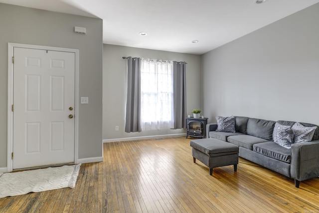 living room featuring light hardwood / wood-style floors and a wood stove